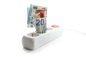 Geldscheine in einer Steckdosenleiste als Metapher für effizientes Energiemanagement und Kosteneinsparungen im Haushalt gemäß den Tipps für Wärme ohne hohe Kosten.